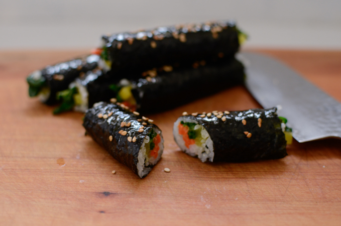 Mini seaweed roll is sliced in half and showing the inside of the roll.