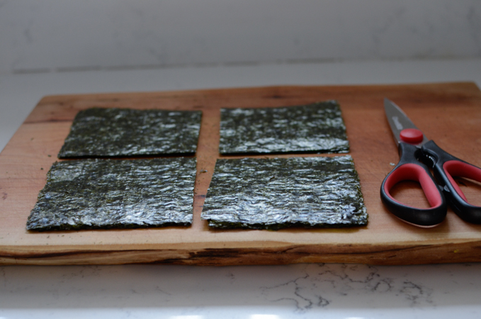 Roasted seaweed sheets are cut into quarter with kitchen scissors.