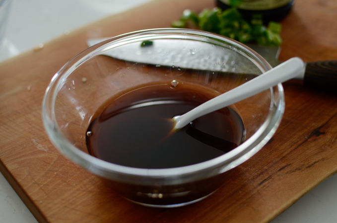 Soy sauce and syrup are mixed in a small bowl to use for Korean potato side dish.
