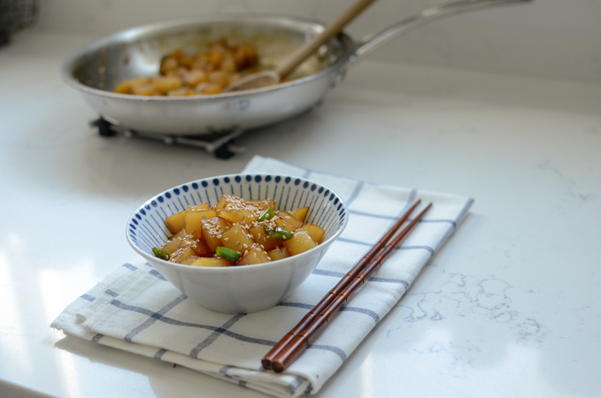 Gamja Jorim, Korean potato side dish, is sereved in a small bowl with chopsticks