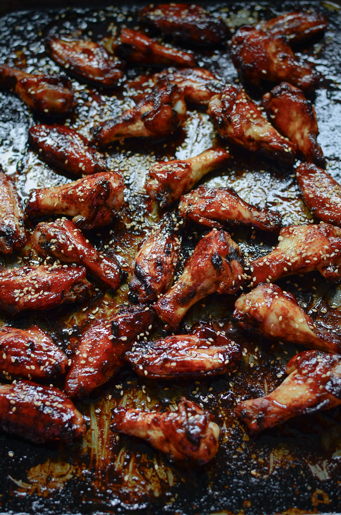 Chicken wings are baked in honey balsamic glaze and garnished with sesame seeds.