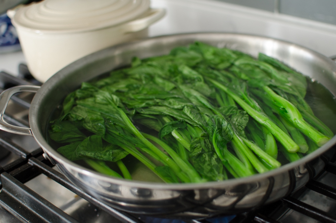 Fresh choy sum blanching in water.