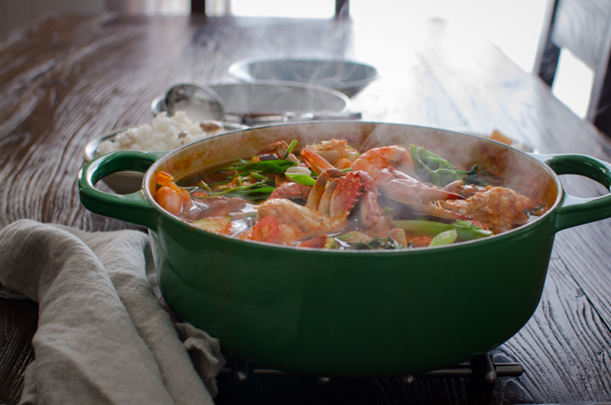 Steaming hot Korean crab stew is placed on a hot rack on the table.