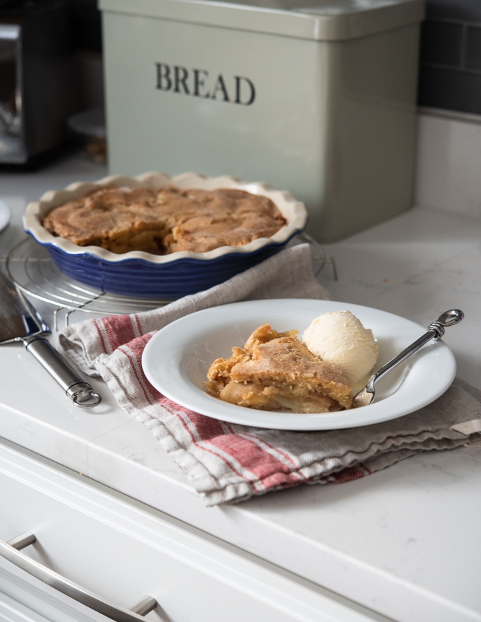 A slice of no-crust apple pie is served with vanilla ice cream.