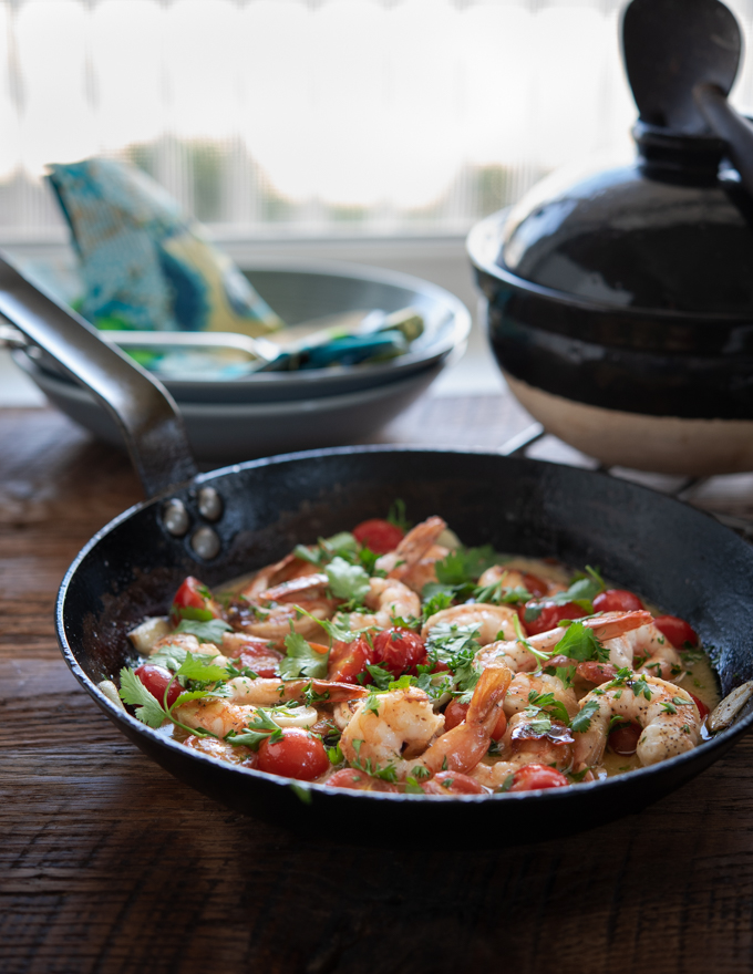 Shrimp and Tomatoes are cooked  with Lemon Butter Sauce in a skillet.