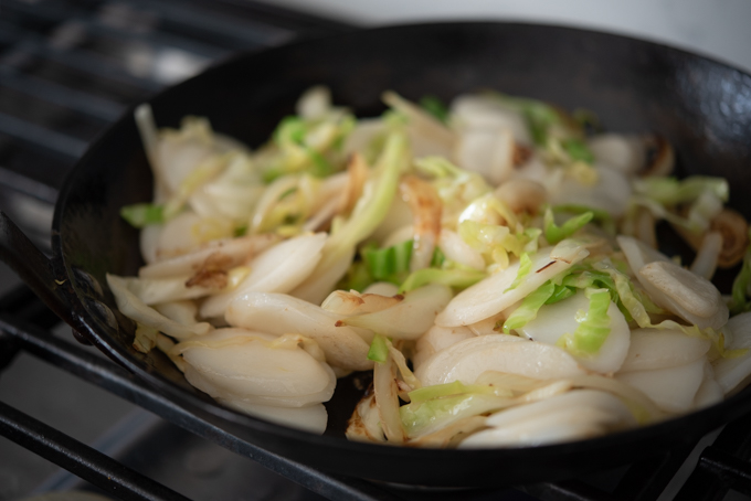 Rice cake rounds stir-frying in a skillet.
