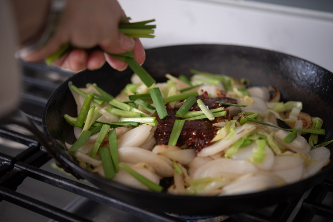Vegetables are added to rice cake stir-fry.