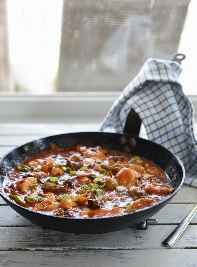 A skillet dish made with oyster, soft tofu, and kimchi is ready to serve.