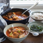 Kimchi Stew (Kimchi Jjigae) with Tomatoes is served with rice and roasted seaweed.