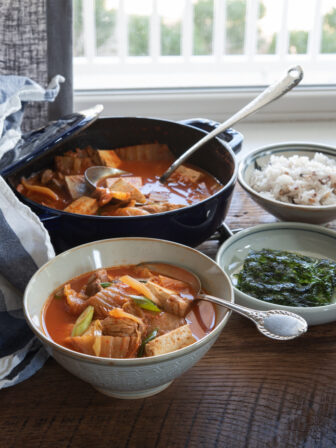 Kimchi Stew (Kimchi Jjigae) with Tomatoes is served with rice and roasted seaweed.
