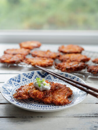 Cheesy Kimchi Potato Pancakes are garnished with a dollop of sour cream.