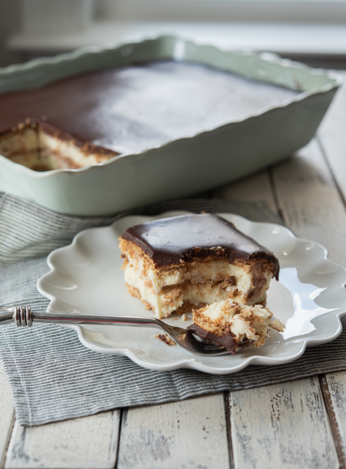 No-bake eclair cake with homemade pastry cream, graham crackers, and chocolate ganache.