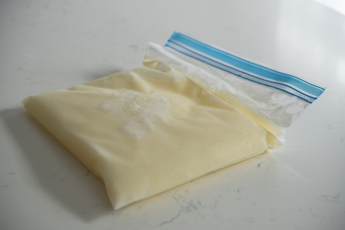 A plastic zip bag filled with milk is frozen.