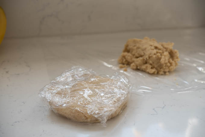 Divided cookie dough covered with plastic wraps.