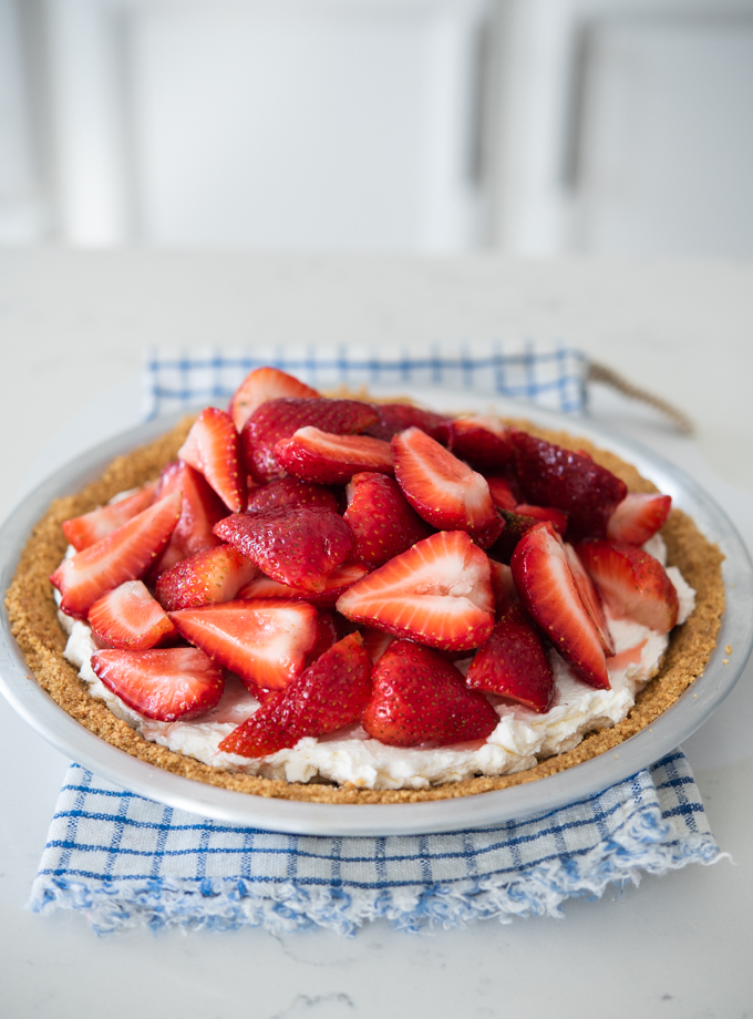 Fresh strawberry pie made with creamy mascarpone cheese filling is made in a graham cookie crust.
