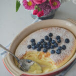 Feather-light lemon pudding cake is spooned with custard filling and fresh blueberries.