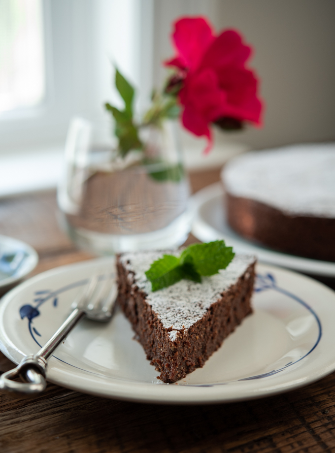 This gluten-free flourless chocolate almond cake (Torta Caprese) is garnished with mint.