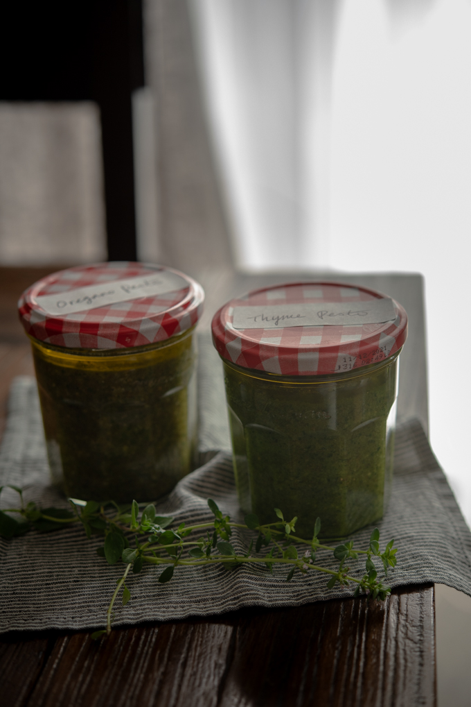 Oregano Pesto & Thyme Pesto are stored in glass jars.