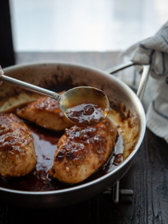 Sticky glaze made with apricot preserve is spooned over chicken breast.