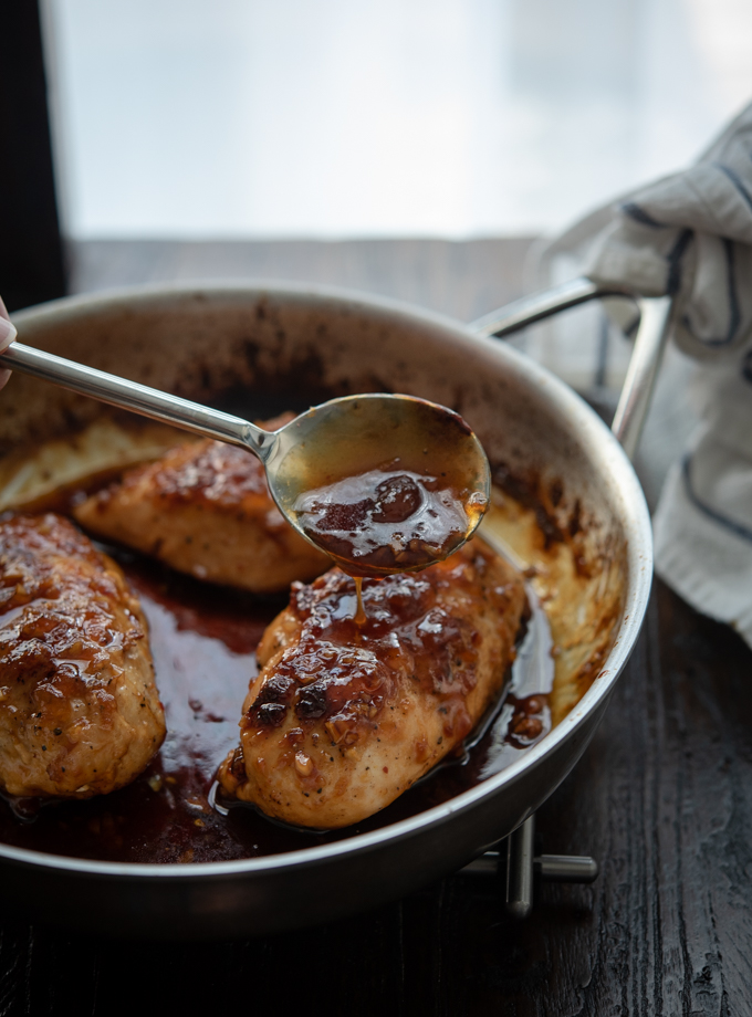 Sticky glaze made with apricot preserve is spooned over chicken breast.