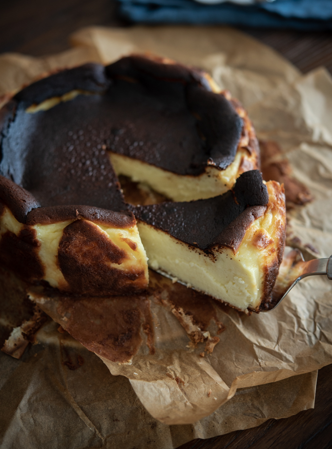 A slice of basque cheese cake shows velvety moist delicious texture.