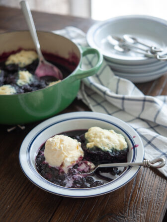 Blueberry dumplings are served with vanilla ice cream.