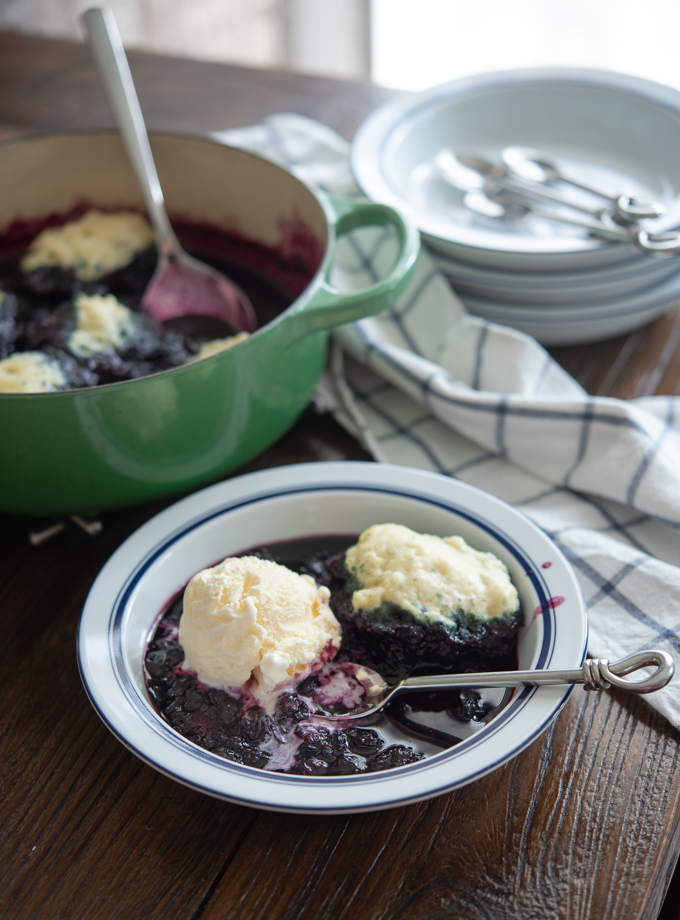 Blueberry dumplings are served with vanilla ice cream.