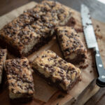 Black bottom banana cake baked with mini chocolate chip is sliced into bars.