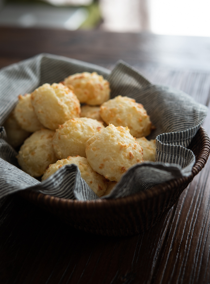 Hot Pão de Queijo are ready to serve in a basket.