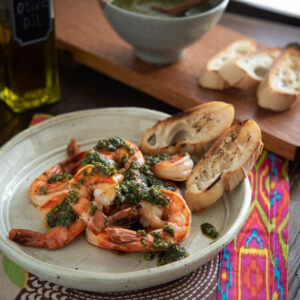Mixed herb pesto made with mint and basil are topped over grilled shrimp