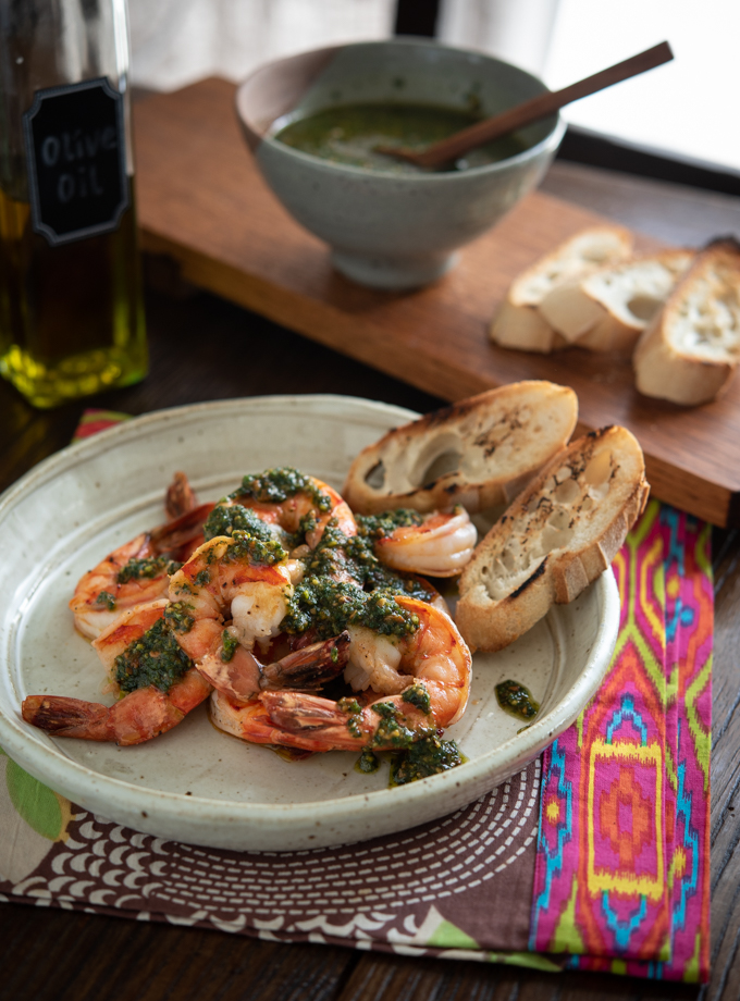Mixed herb pesto made with mint and basil are topped over grilled shrimp.