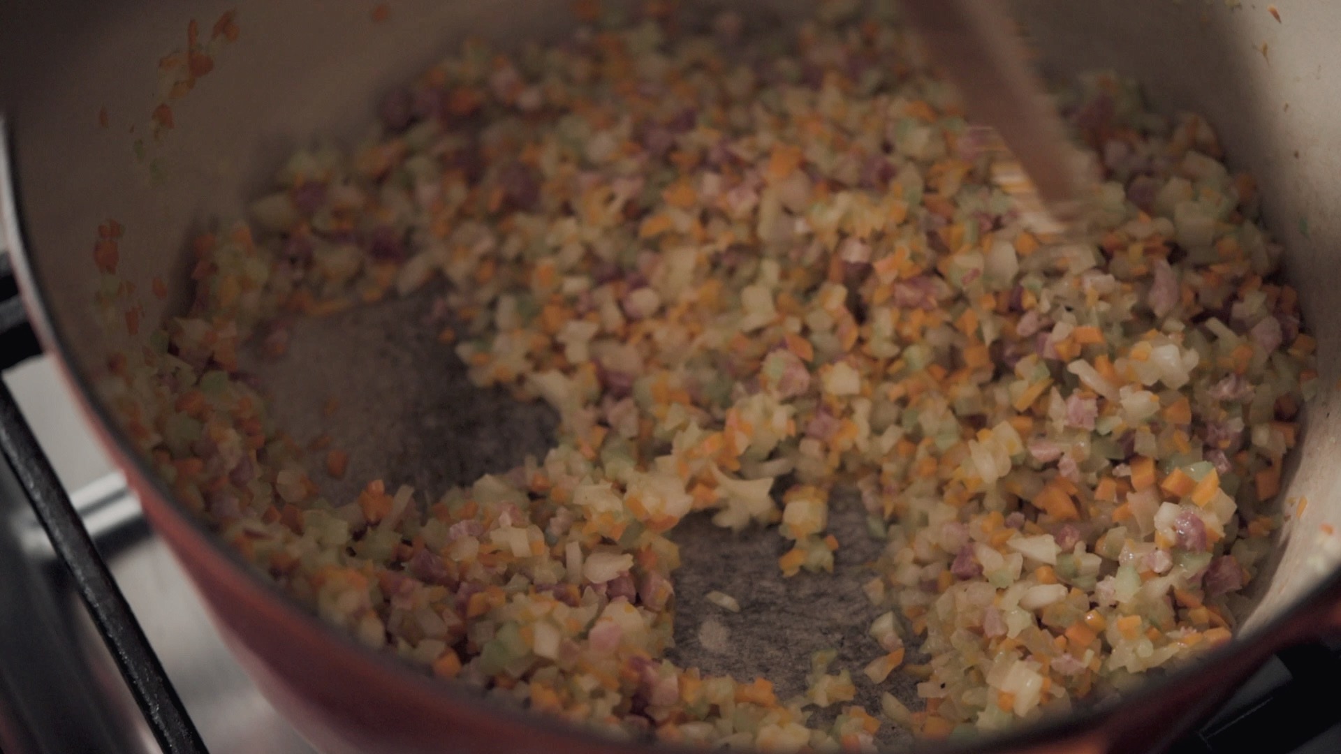 Vegetables sautéing in a pot.