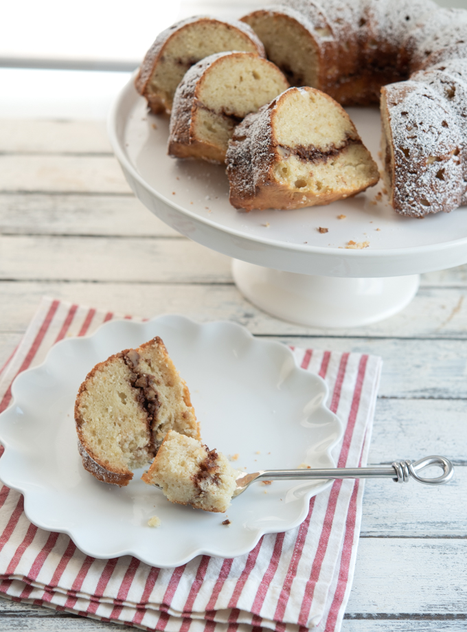 A slice of apple cinnamon bunt cake shows fragrant and nutty cinnamon walnut filling.
