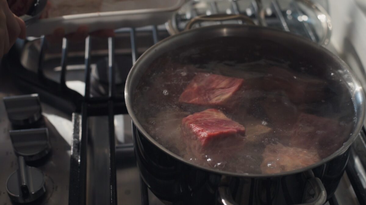 Beef short ribs are added to boiling water prior to making Galbi-Jjim.