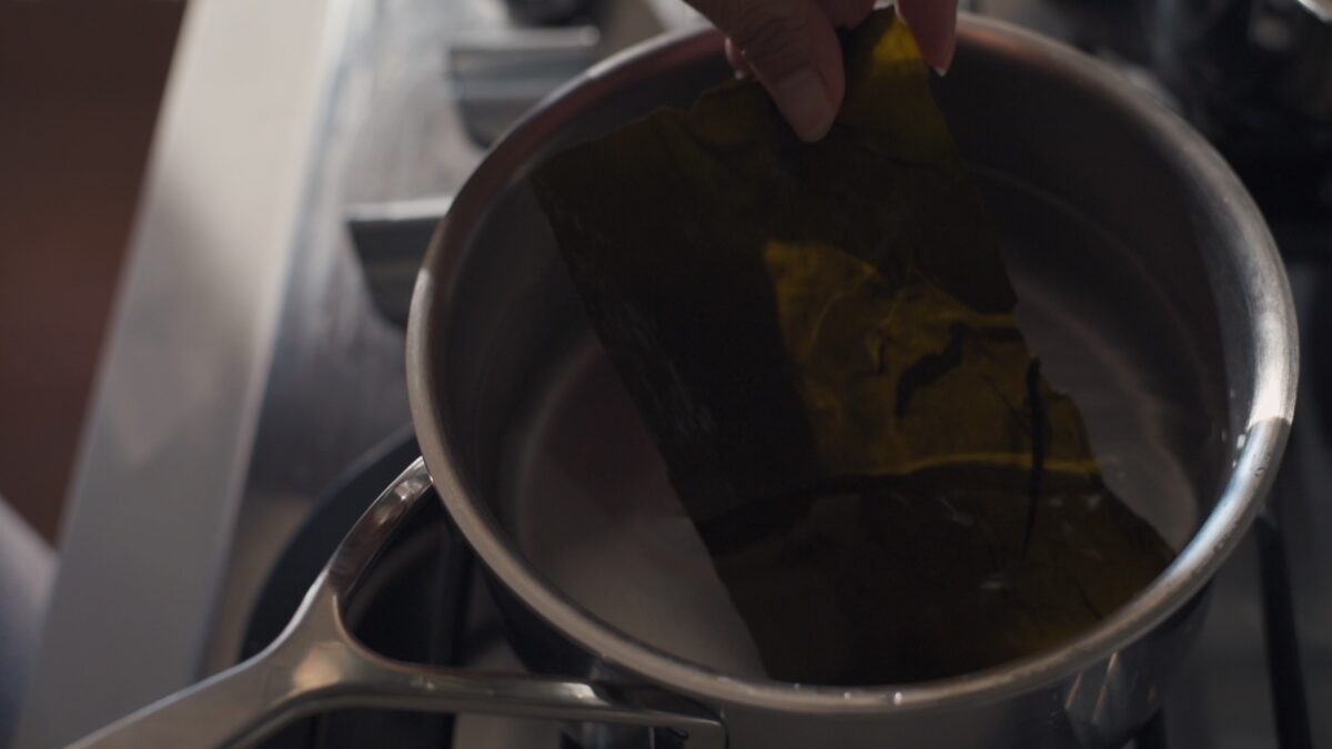 A large piece of dried sea kelp added to water to make sea kelp stock.