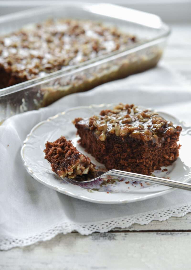 A slice of chocolate oatmeal cake is on a plate with a fork