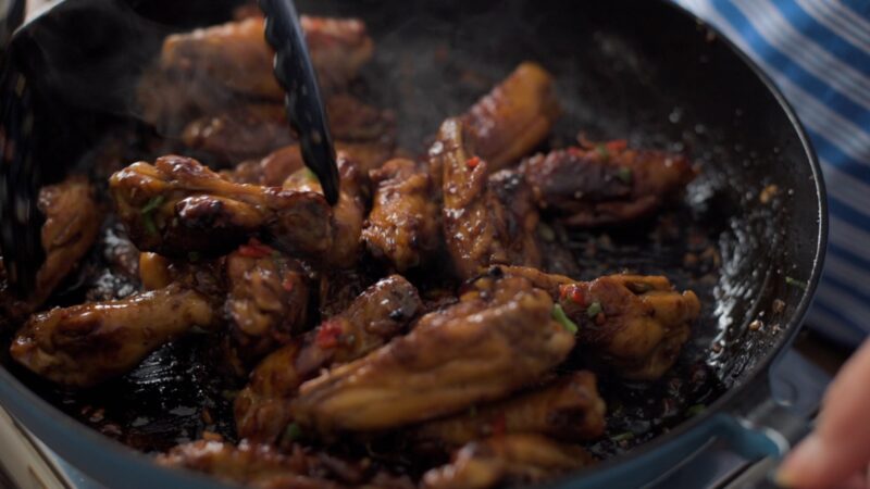 Honey garlic sauce is thickened and coating the chicken.