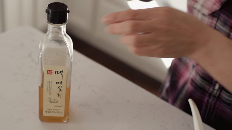 Korean plum syrup in a bottle showing its golden color.