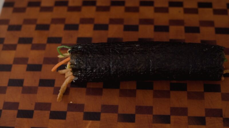 Kimbap rolled on a cutting board.