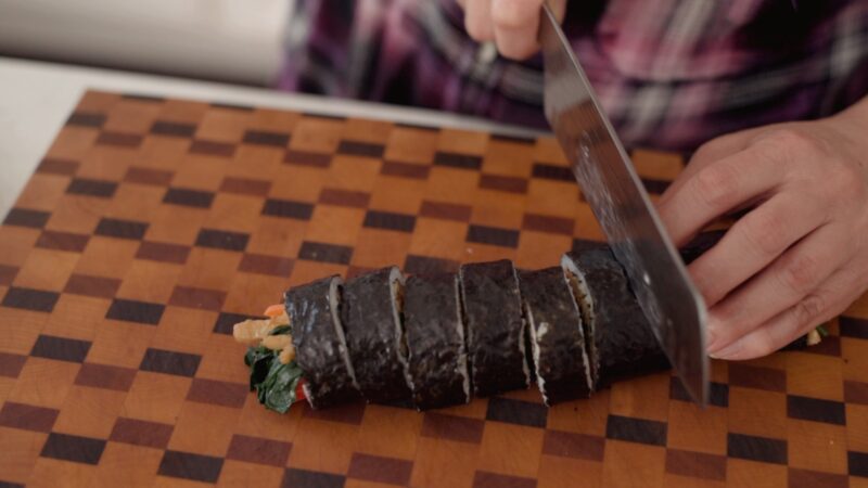 One kimbap is nicely rolled on a cutting board