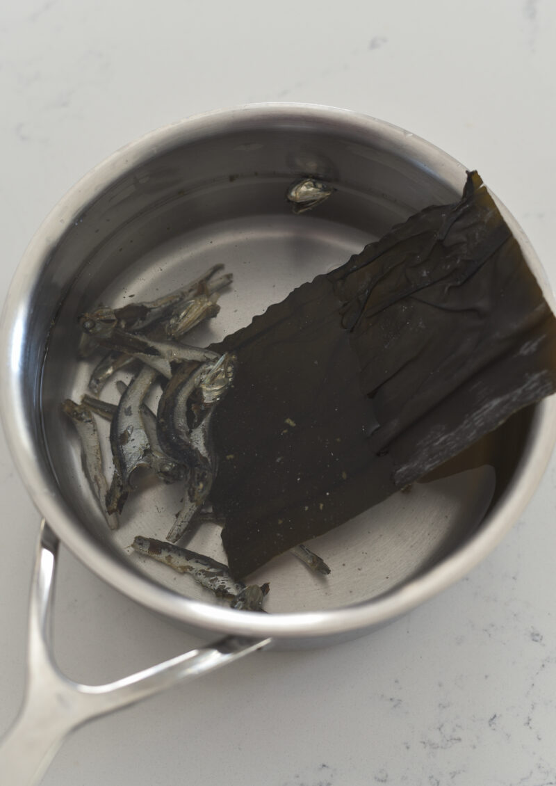 Dried anchovies and sea kelps are combined with water in a pan.