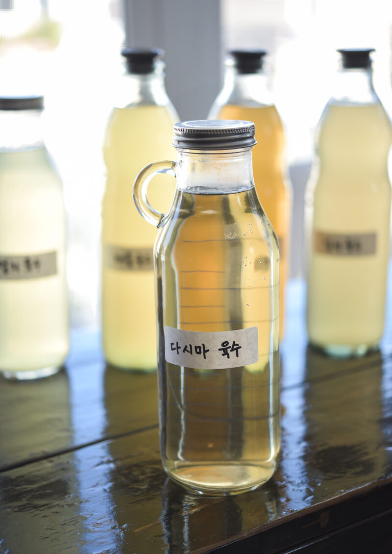 Homemade Korean sea kelp stock is stored in a glass jar with a Korean label attached.