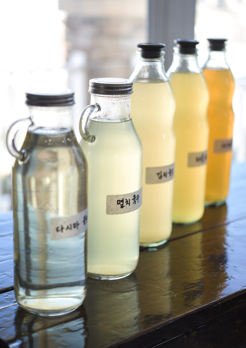 Different types of Korean soup stocks with label are displayed on the table.