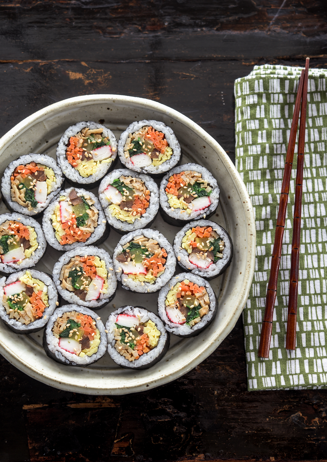 A top view of colorful kimbap (gimbap) slices in a plate.