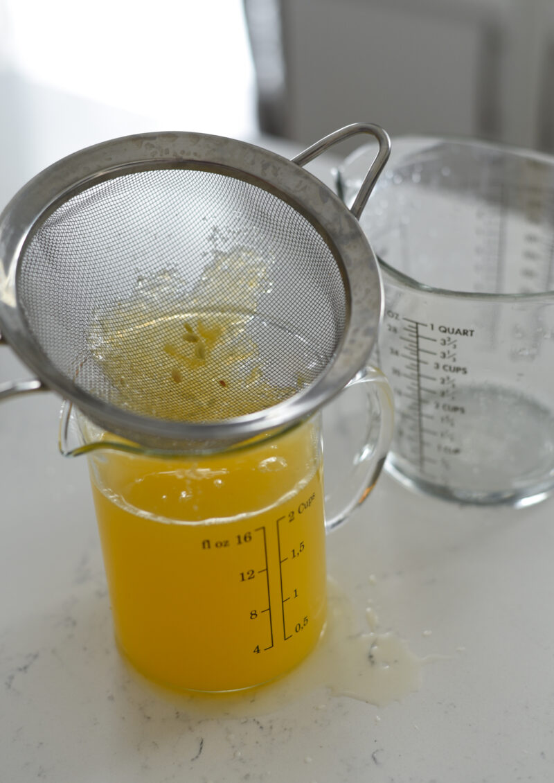 A fine mesh strainer is used for collecting small seeds from the lemon juice.