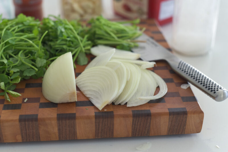 Onion is sliced on a cutting board.