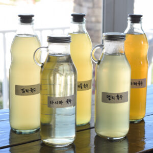 Bottles of various Korean soup stocks with their labels are placed on a counter.