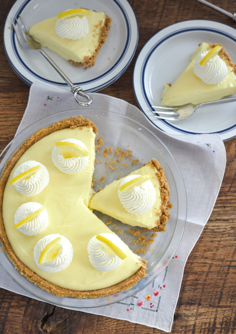 Sour cream lemon custard is sliced and plated on to couple of small dessert plates.