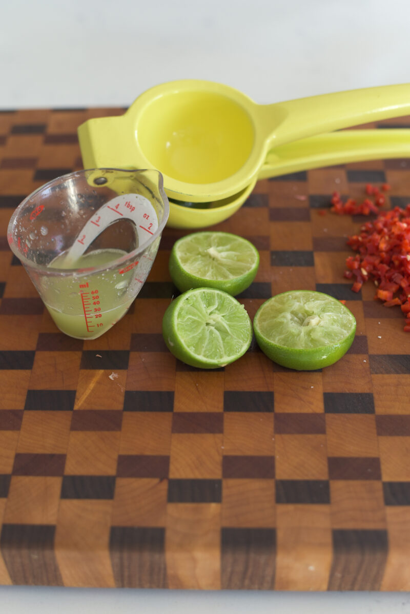 Fresh lime is squeezed out to collect the juice for making Thai beef salad dressing.