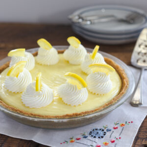 Luscious sour cream lemon custard is filled in a graham cookie crust and topped with whipped cream.
